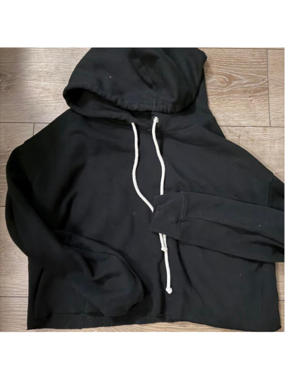 Black oversized cropped hoodie with a raw-cut hem, roomy slouchy fit, drop shoul